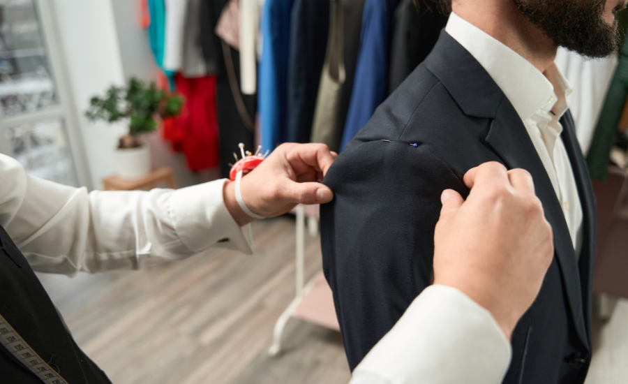 A tailor adjusting a man's suit jacket, ensuring a perfect fit for a formal occasion.