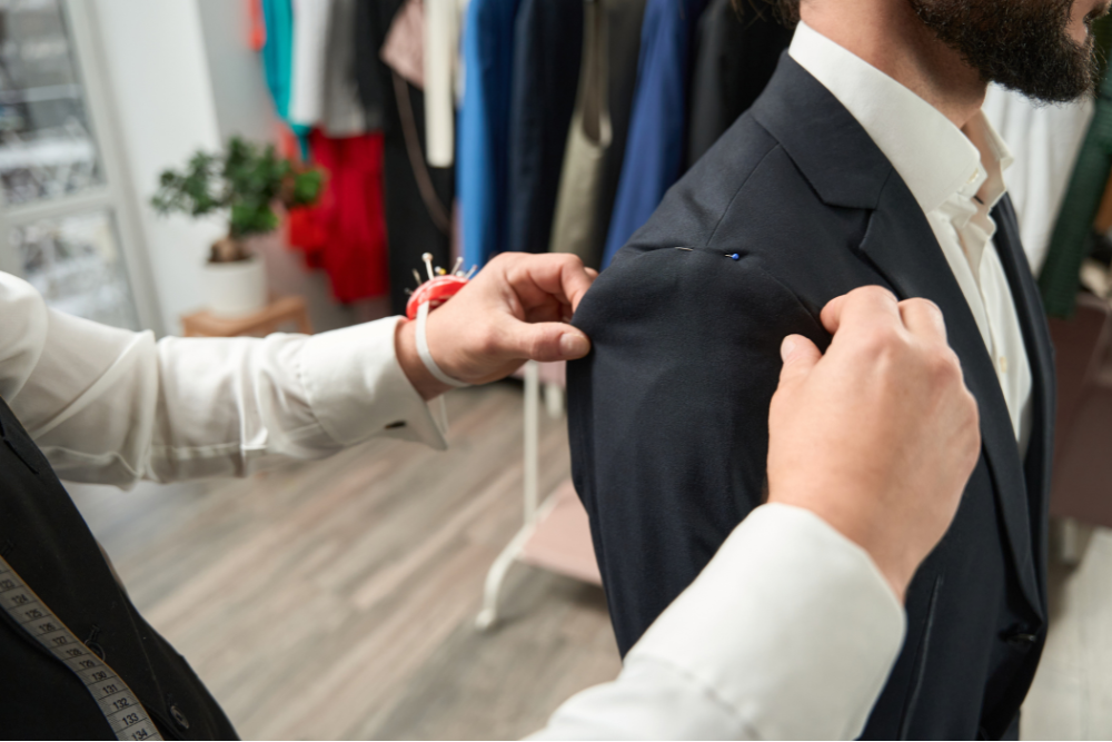 A tailor measuring a suit for a perfect fit on his client